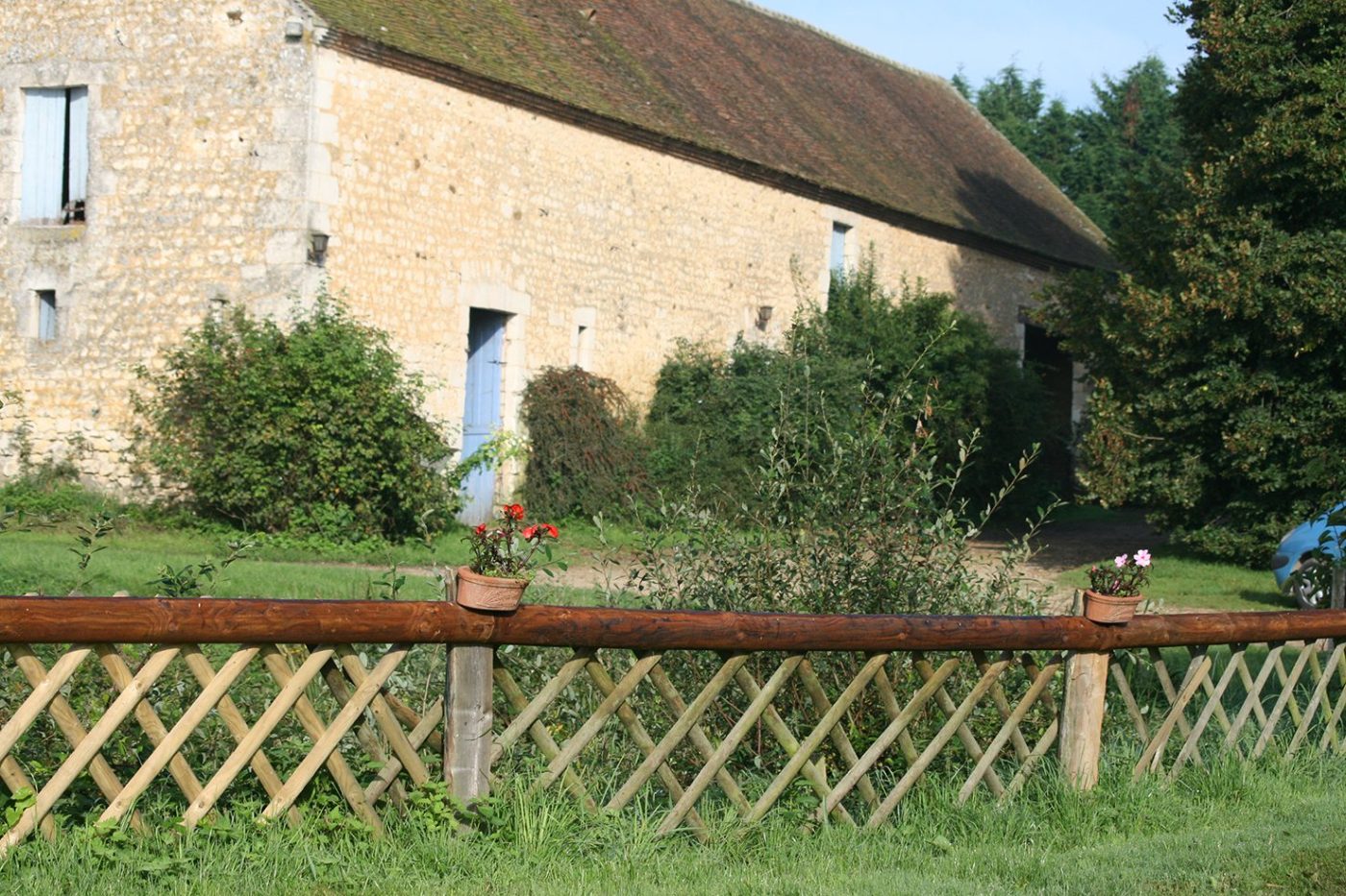Les bâtiments en pierre du haras et leur barrière en bois